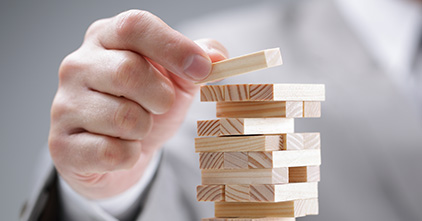 hand putting a jenga block on top of other blocks