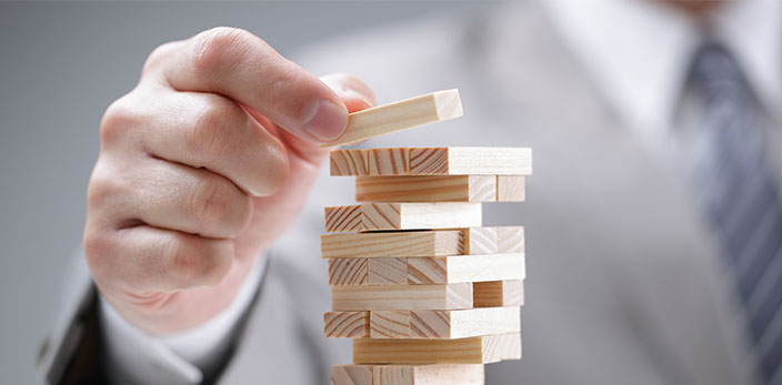 hand putting a jenga block on top of other blocks