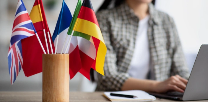 Language Training Trends_Desk with laptop and small flags