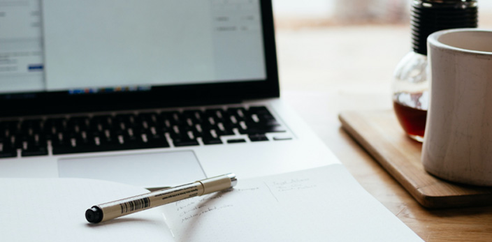 laptop with a pen and cup