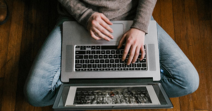 person in an indian seat position with a laptop