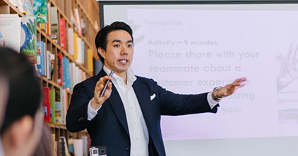 asian man explaining a concept to a group of people