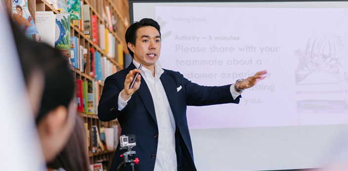 asian man explaining a concept to a group of people