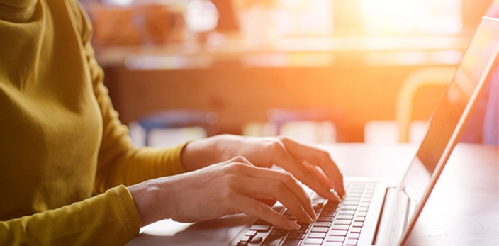 close up of person working on laptop in the afternoon