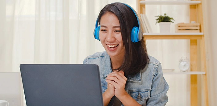 creating-positive-candidate-experience-smiling-asian-female-headphones-laptop