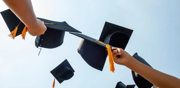 Graduation caps being held up