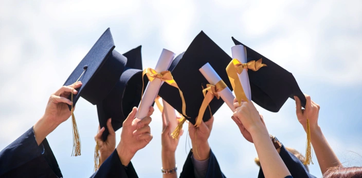 Graduation caps held in the air
